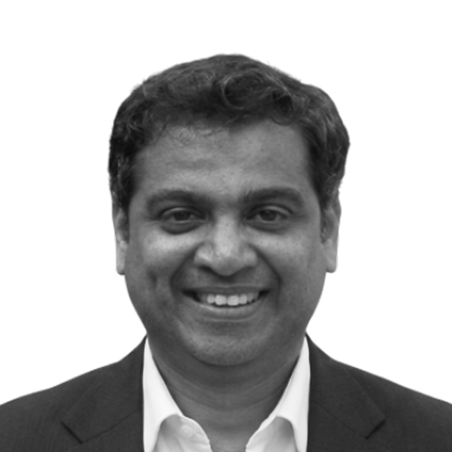 Retrato a preto e branco de Durga Prasad Vemula, de fato e sorridente.