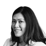 Retrato a preto e branco de Marcella Pratama, de camisa e sorridente.
