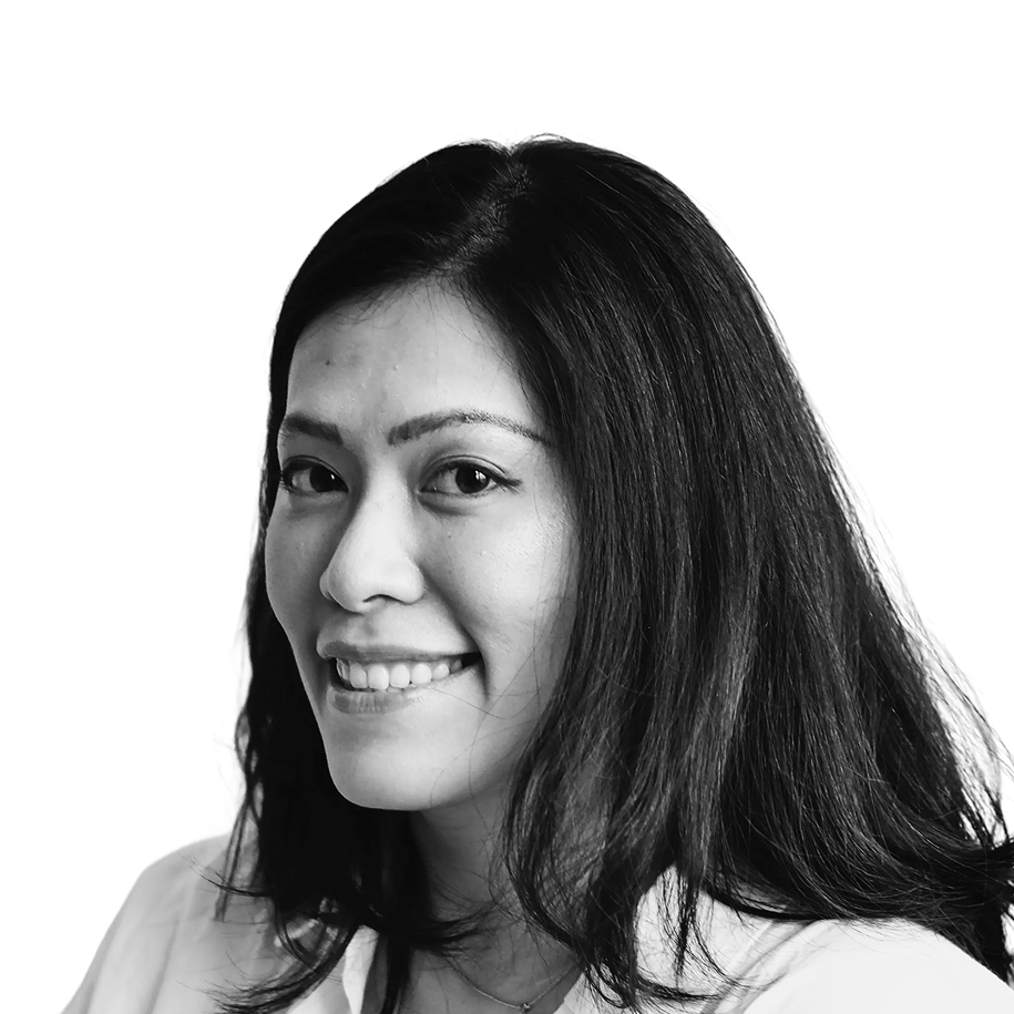Retrato a preto e branco de Marcella Pratama, de camisa e sorridente.