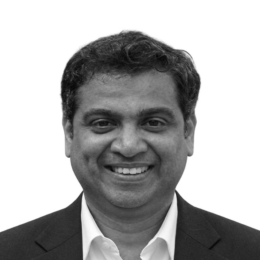 Retrato a preto e branco de Durga Prasad Vemula, de fato e sorridente.