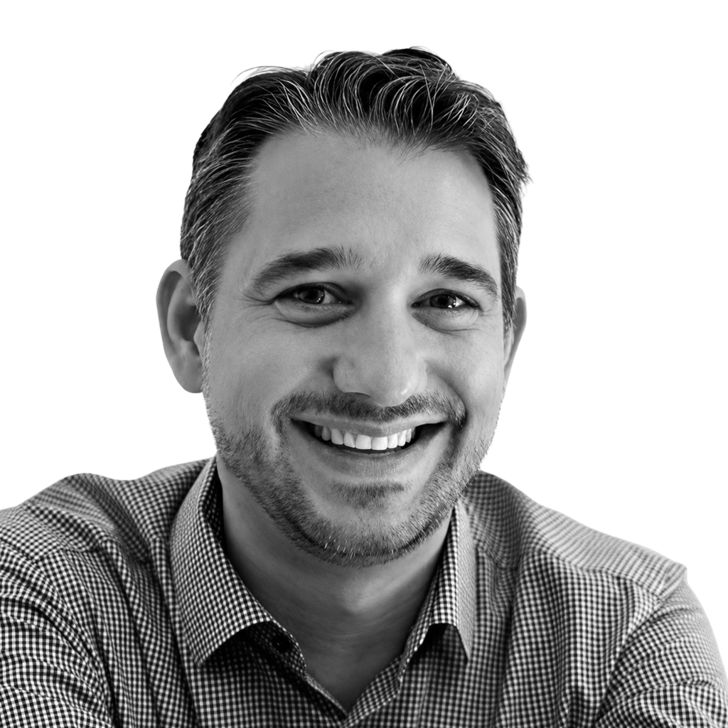 Retrato a preto e branco de Florian Egger, de camisa e sorridente.