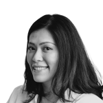Retrato a preto e branco de Marcella Pratama, de camisa e sorridente.