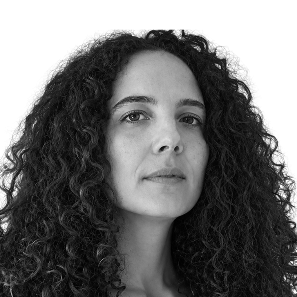 Retrato a preto e branco de Camilla Briganti, com uma expressão descontraída.